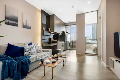 Modern living room with open kitchen and balcony view in stylish apartment