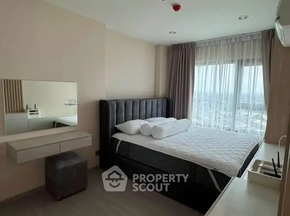 Modern bedroom with large window and stylish furnishings in a high-rise apartment.