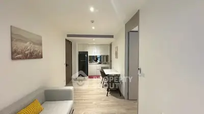 Modern open-plan living room with sleek kitchen and cozy seating area.