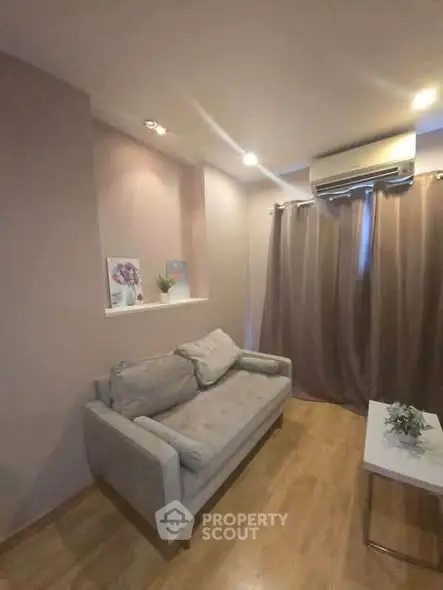 Cozy living room with modern sofa and air conditioning, perfect for relaxation.