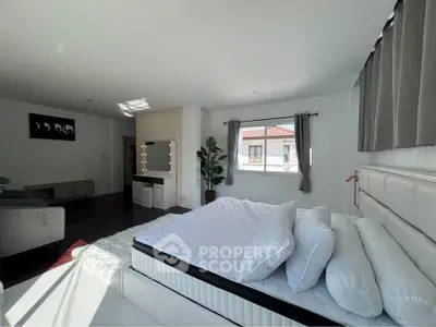 Spacious modern bedroom with elegant decor and ample natural light