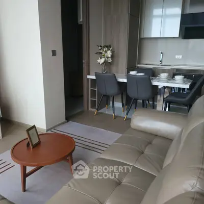 Modern living room with open kitchen, stylish furniture, and elegant decor in a contemporary apartment.