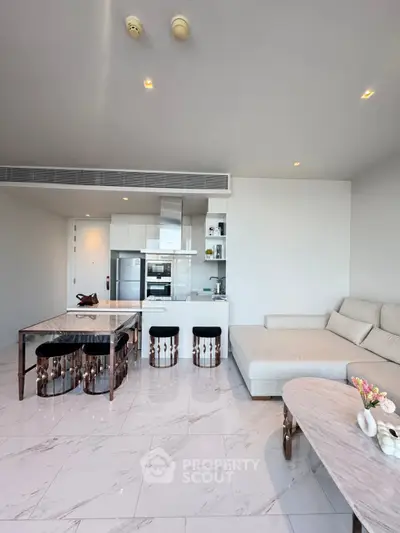 Modern open-layout living room with sleek kitchen and stylish furniture, perfect for contemporary living.