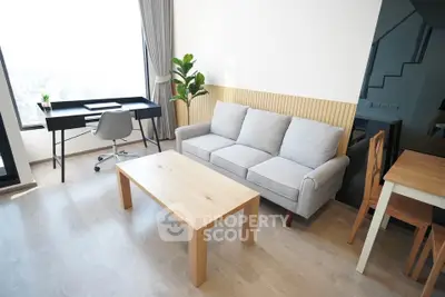 Modern living room with stylish furniture and large window offering city views.