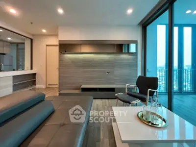 Modern living room with sleek furniture and large windows offering city views.