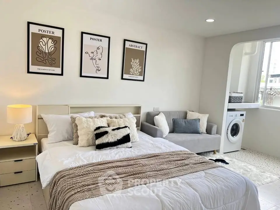 Chic bedroom with modern decor and in-room washing machine, perfect for urban living.