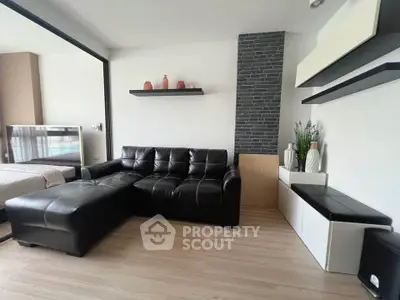 Modern living room with black leather sofa and stylish decor