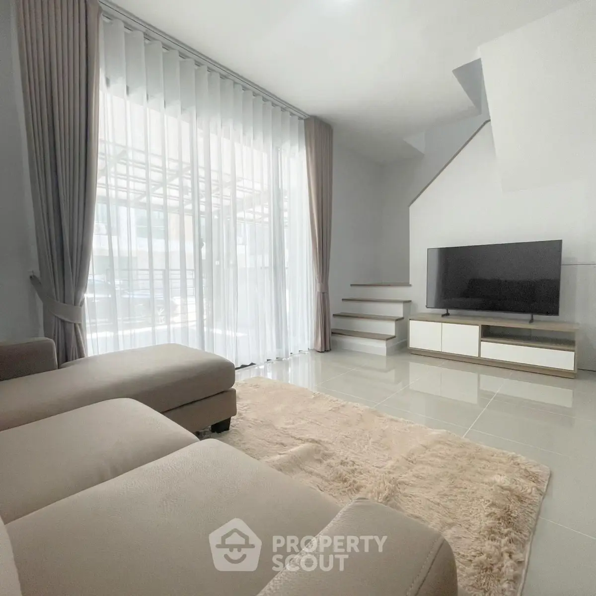 Spacious modern living room with large windows and elegant decor