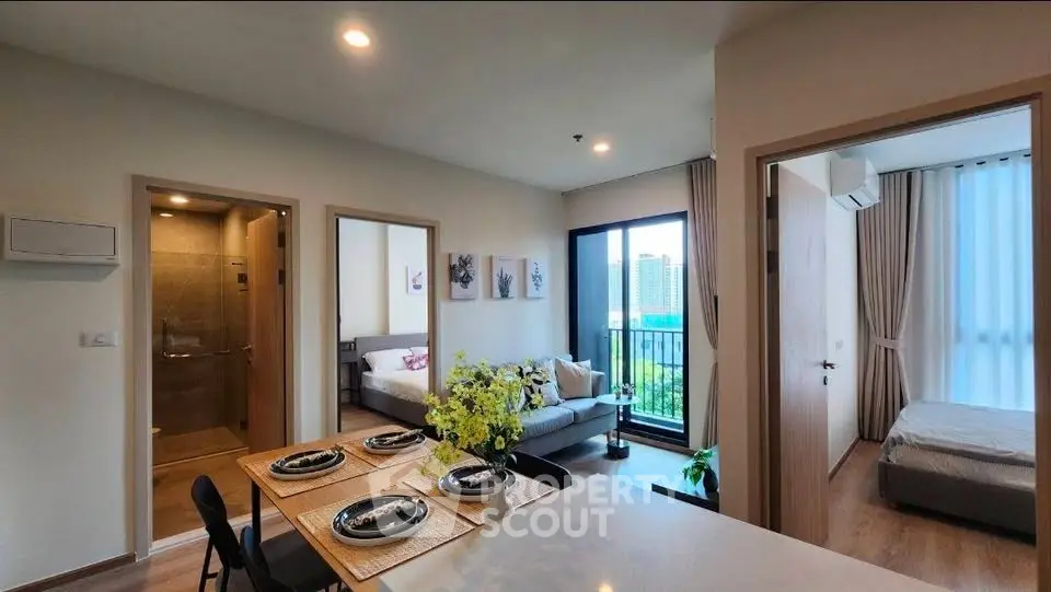 Modern apartment interior with open layout, featuring a cozy living room, dining area, and bedroom with city view.