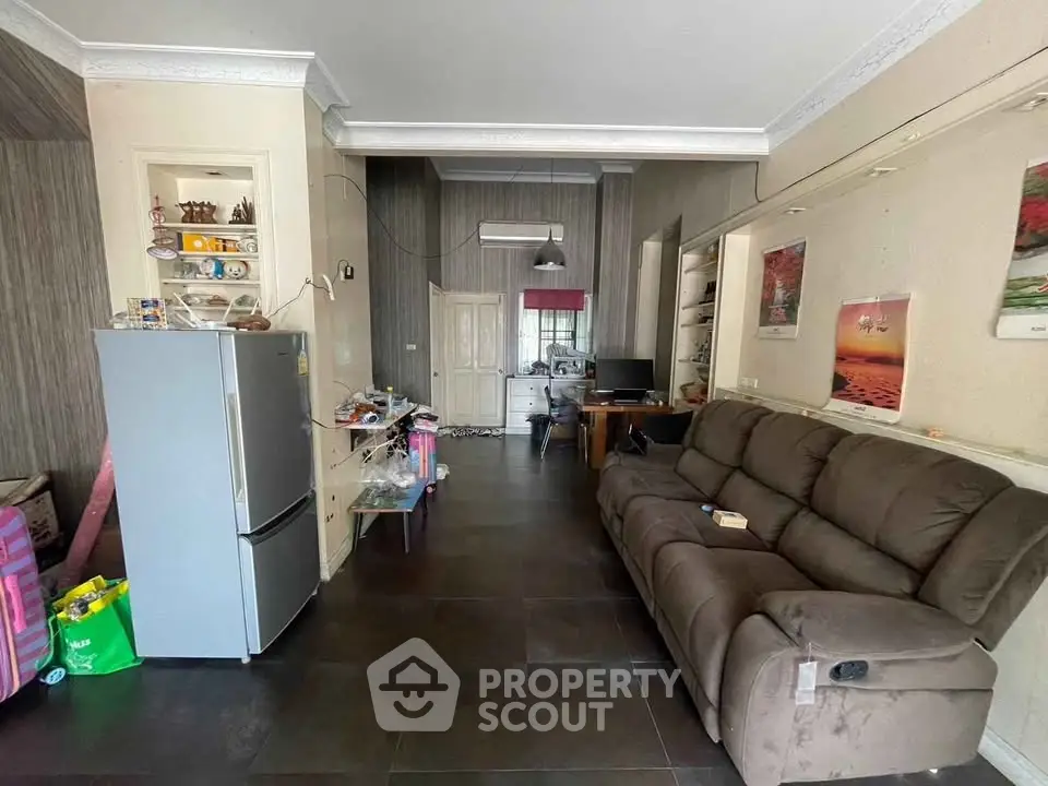 Spacious living room with modern furniture and open kitchen layout, perfect for family gatherings.