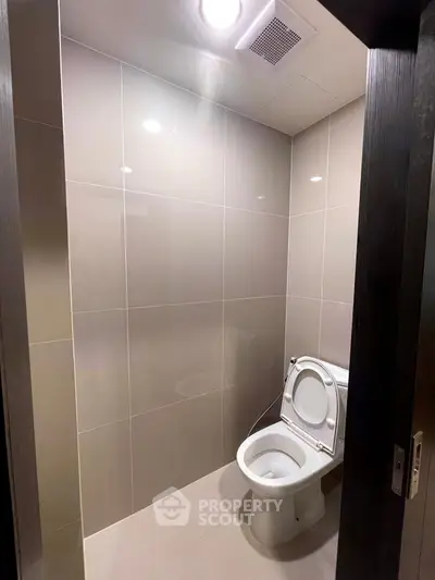 Modern bathroom with sleek tile design and contemporary toilet fixture.