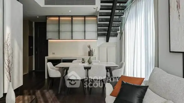 Modern living room with elegant dining area and stylish staircase in a contemporary home.