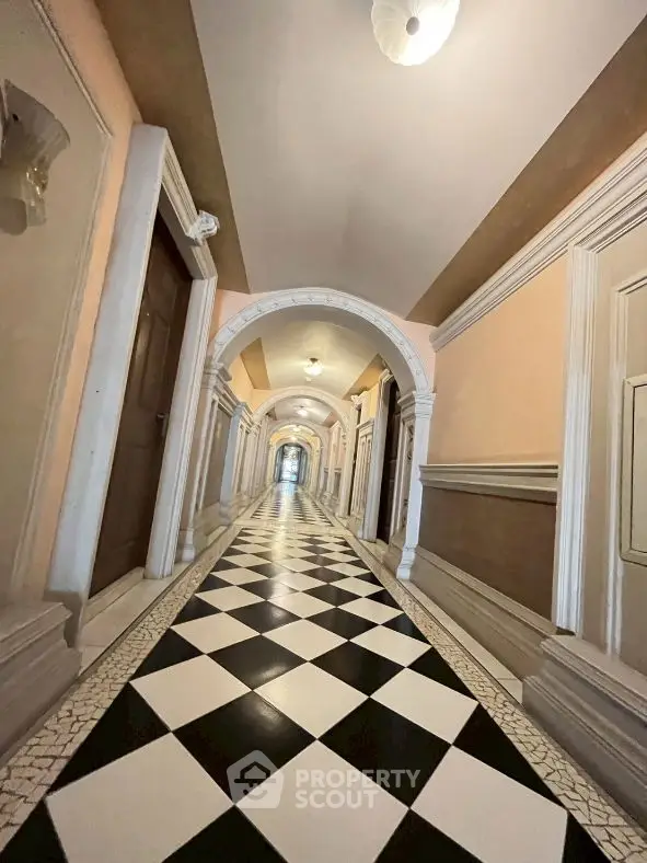 Elegant hallway with checkered floor and arched doorways in luxury building
