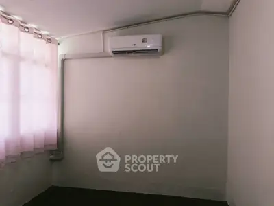 Minimalist room with air conditioning and soft natural light through curtains.