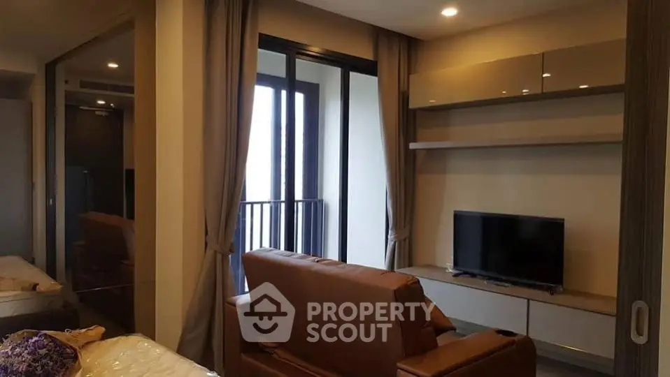 Modern living room with sleek furniture and balcony view in a stylish apartment.