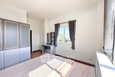 Bright bedroom with large window and stylish wardrobe in modern home