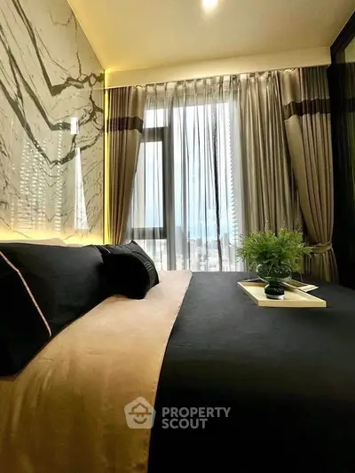 Luxurious bedroom with elegant decor and stunning city view through large window.