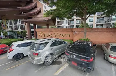 Charming residential building with lush greenery and convenient parking area.