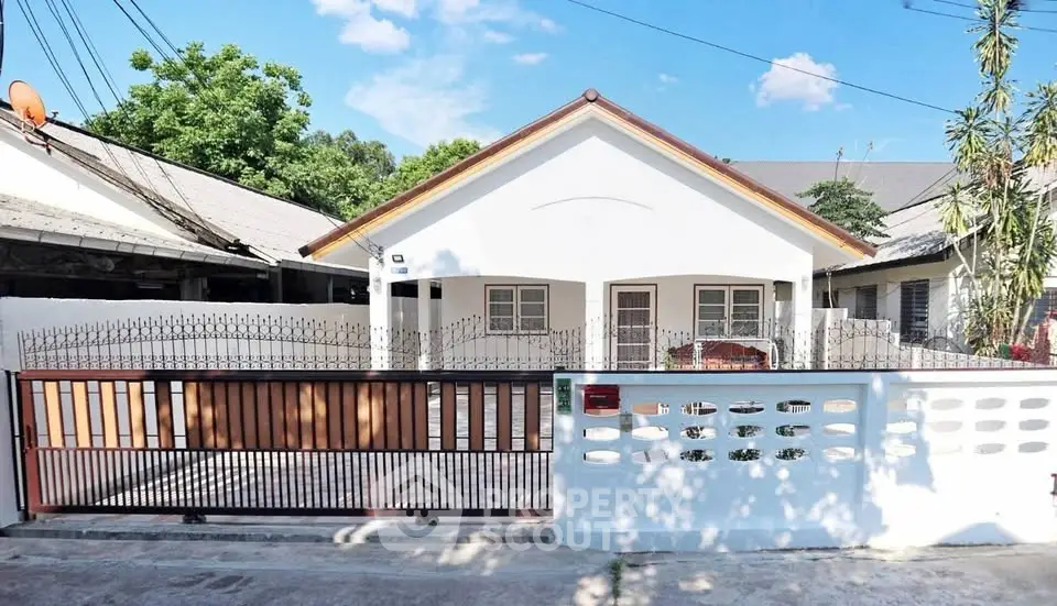 Charming single-story house with gated entrance and spacious driveway in a serene neighborhood.