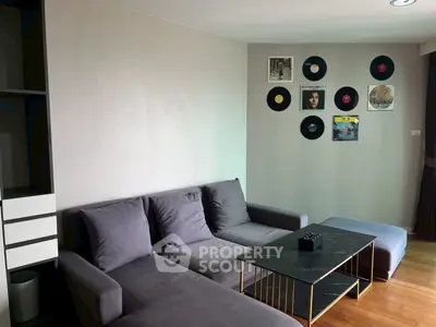 Stylish living room with modern gray sofa and vinyl record wall decor