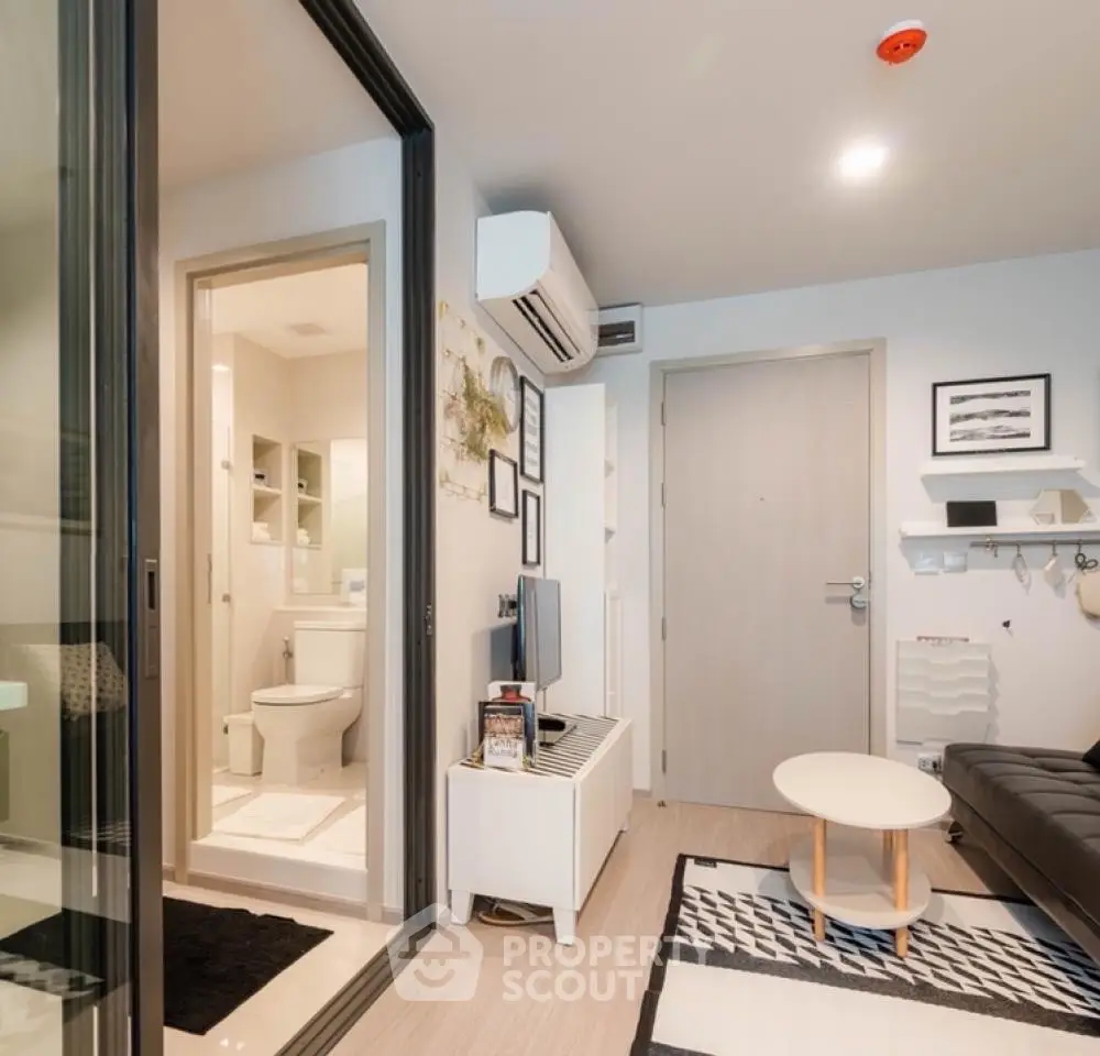 Modern apartment interior with living room and bathroom, featuring sleek furniture and contemporary design.