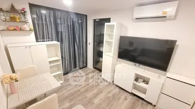 Modern living room with sleek white furniture, large flat-screen TV, and elegant wood flooring, complemented by a cozy ambiance and air conditioning for comfort.