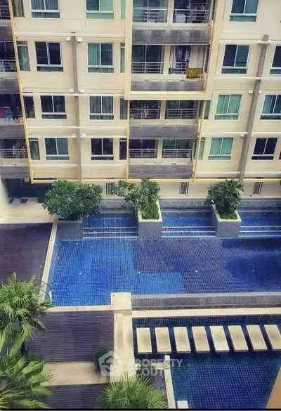 Luxurious apartment building with stunning pool view and modern design.
