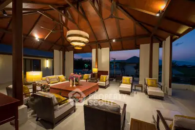 Luxurious open-air living room with elegant wooden ceiling and stunning sunset view.
