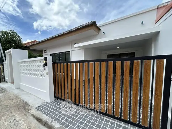 Modern single-story house with stylish wooden gate and clean exterior design.