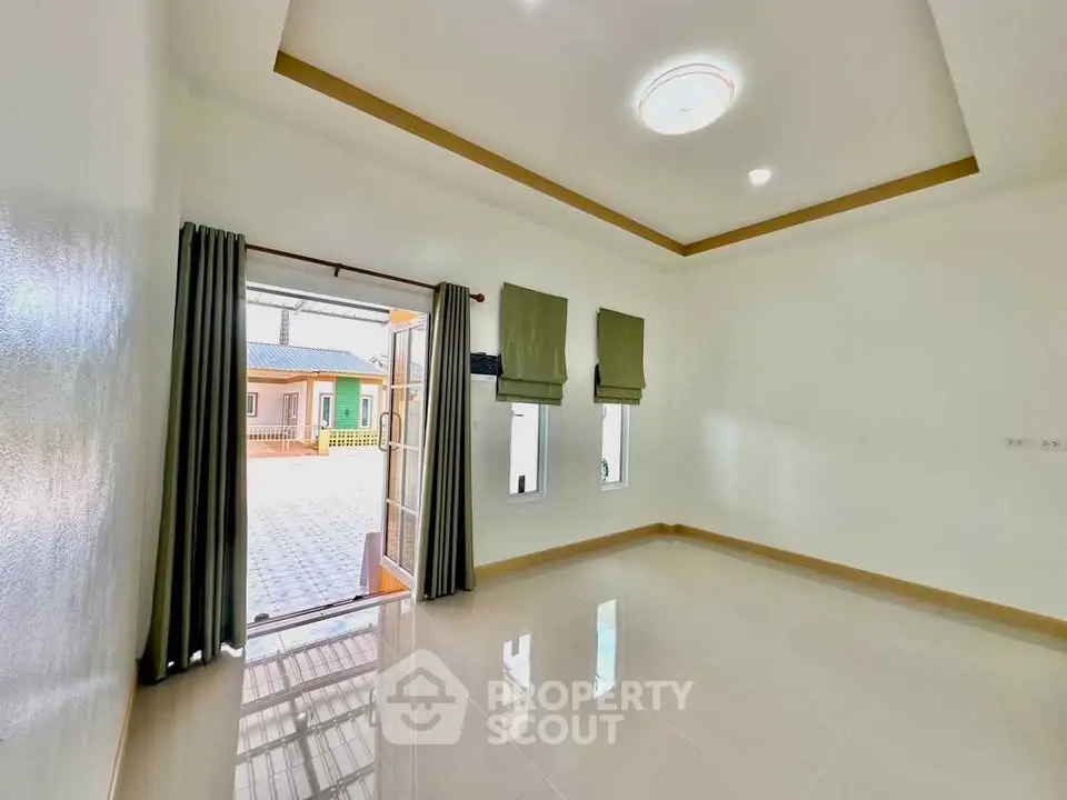 Spacious bright room with open door leading to outdoor patio area
