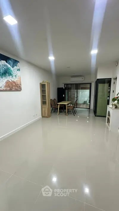 Spacious modern living room with sleek tile flooring and elegant furniture, perfect for entertaining guests.