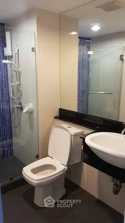 Modern bathroom with glass shower and sleek fixtures in a contemporary apartment.
