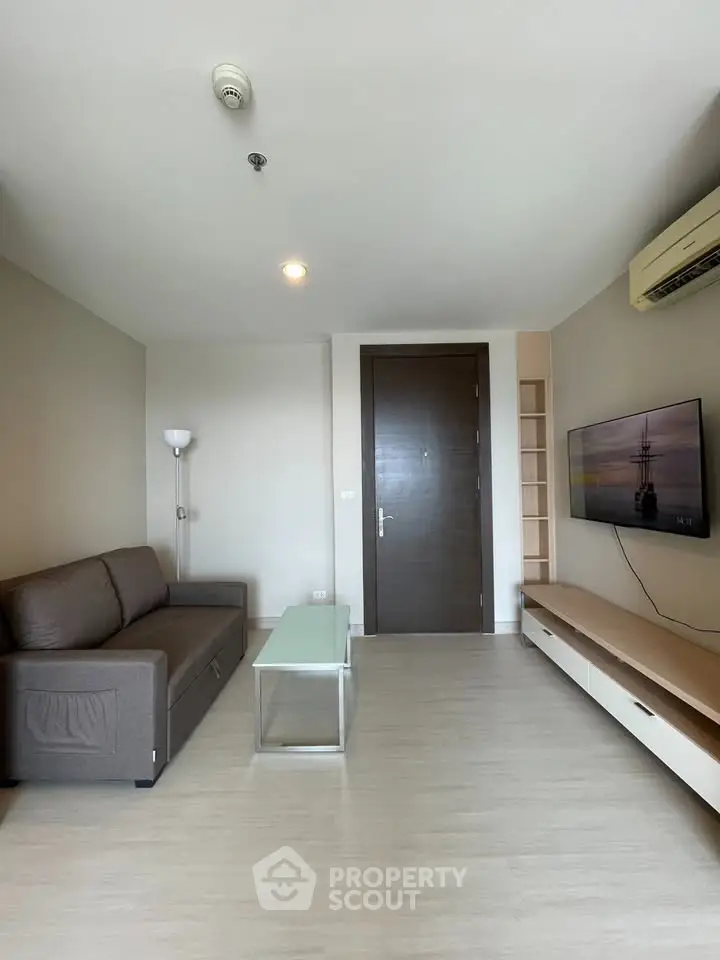 Modern living room with sleek furniture and wall-mounted TV in a stylish apartment.