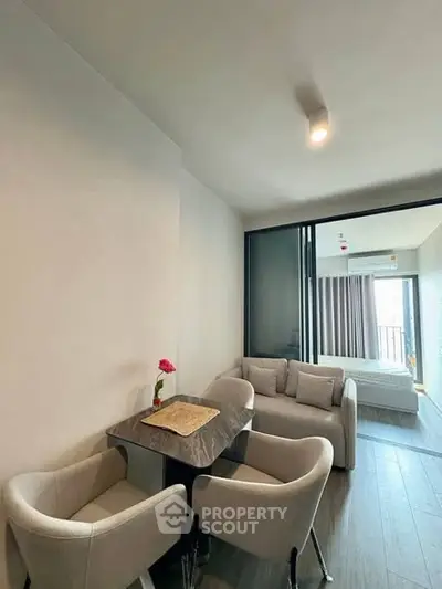 Modern living room with cozy seating and dining area, featuring elegant decor and natural light.