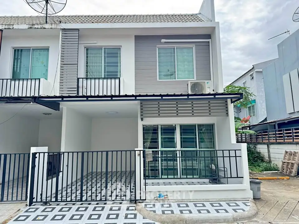 Modern townhouse exterior with balcony and parking space in a quiet neighborhood.