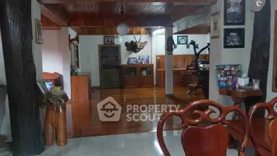 Spacious living room with wooden flooring and elegant decor, perfect for family gatherings.