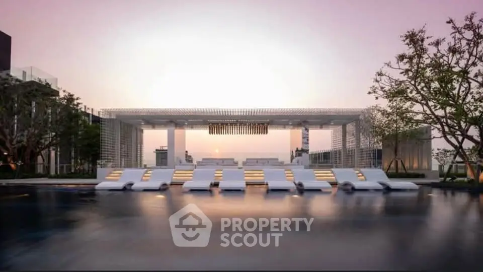 Luxurious rooftop pool area with modern lounge chairs and stunning sunset view.
