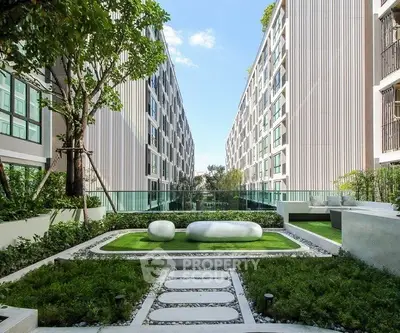 Modern apartment complex with lush garden and contemporary design.