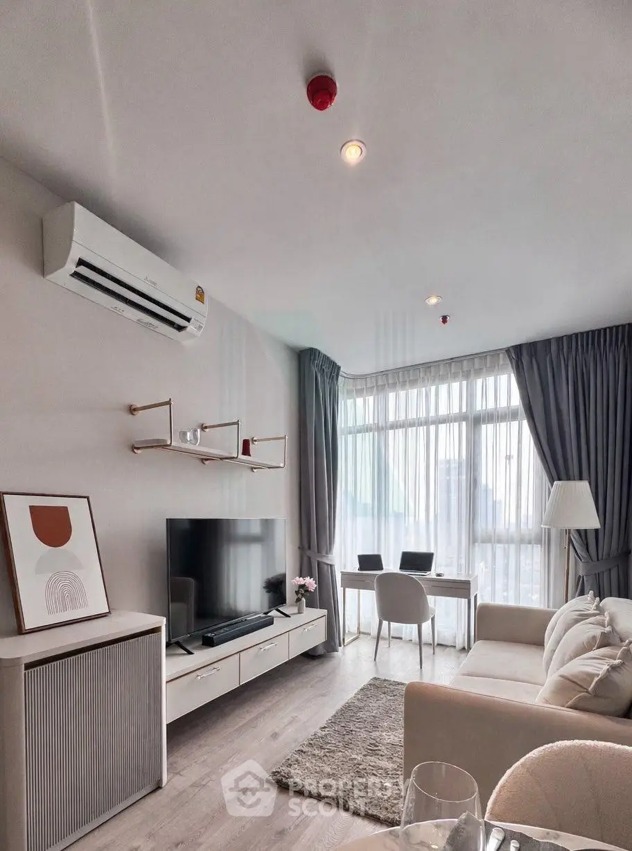 Modern living room with large windows, stylish decor, and cozy seating area in a high-rise apartment.