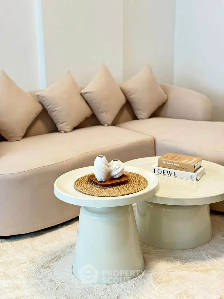 Elegant living room with modern beige sofa and stylish coffee tables