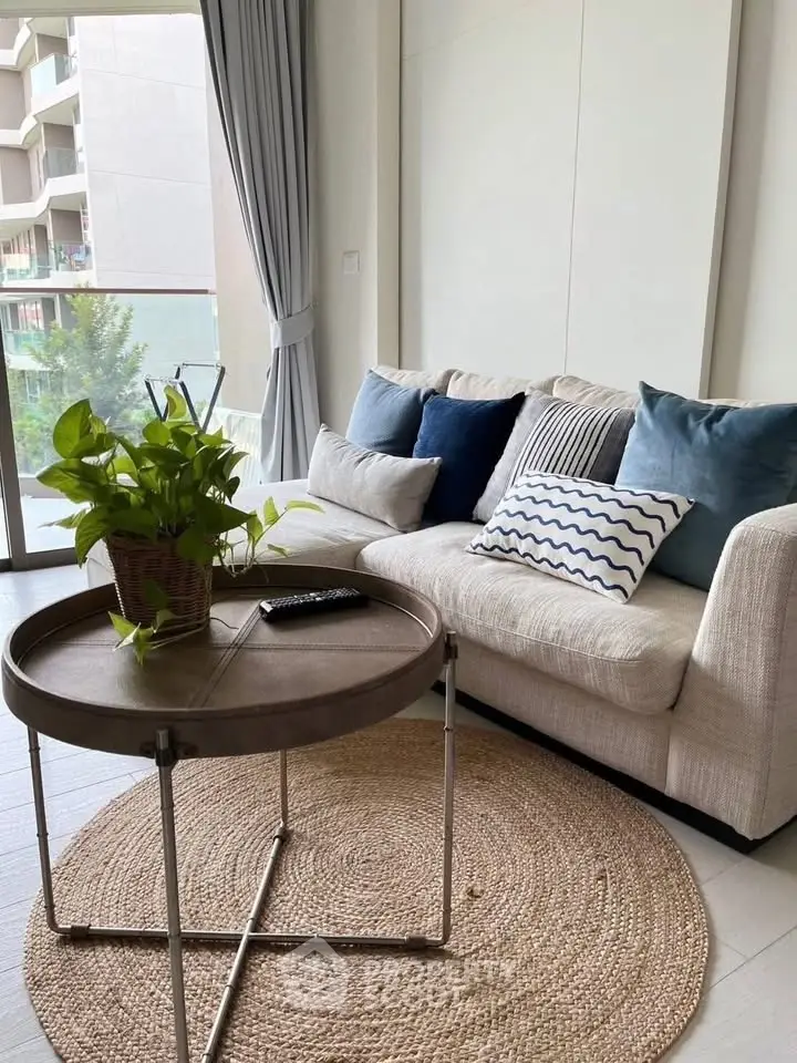 Chic living room with cozy sofa, stylish coffee table, and lush greenery, perfect for relaxation and modern living.