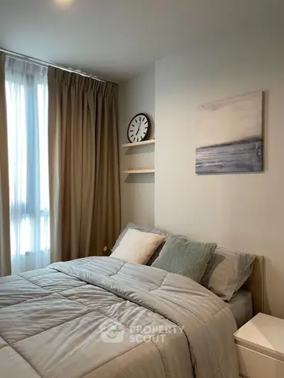 Cozy bedroom with modern decor and natural light in a stylish apartment.