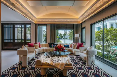 Luxurious living room with elegant decor and large windows offering garden views.