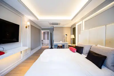 Luxurious bedroom with modern decor and ambient lighting, featuring a large bed and stylish furnishings.
