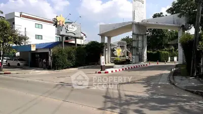 Charming gated community entrance with lush greenery and modern architecture.