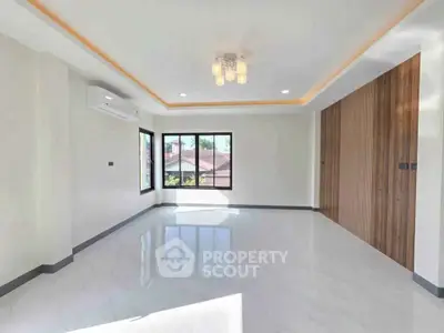 Spacious modern living room with large windows and elegant lighting