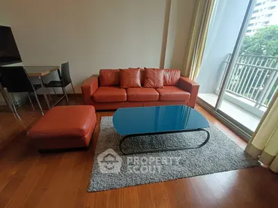 Modern living room with red leather sofa, glass coffee table, and balcony view.