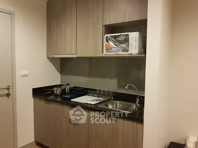 Modern compact kitchen with sleek cabinetry and built-in microwave