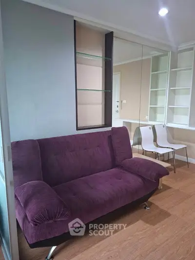 Modern living room with purple sofa and built-in shelves