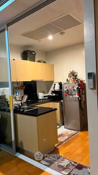 Cozy kitchen with modern appliances and wooden flooring in a compact layout.